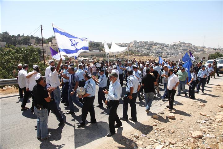 שוטרים ומתיישבים רוקדים יחד בחברון עם ספר התורה