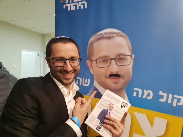 יונתן דובוב ליד השפם שציירו על הפוסטר שלו
