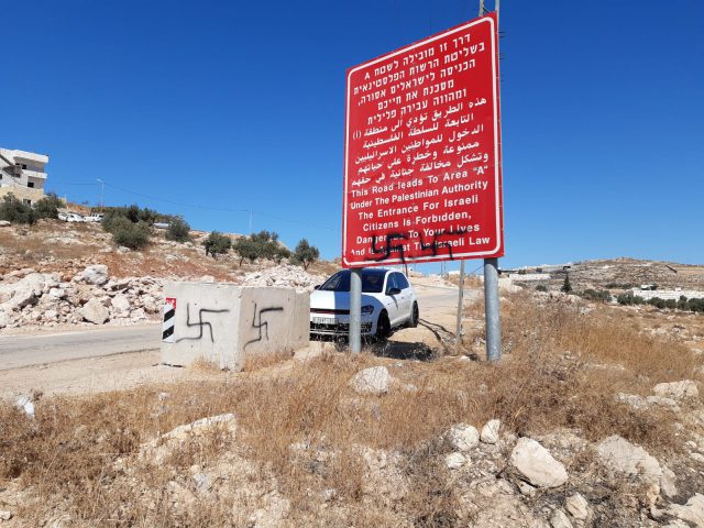 צלבי קרס בסמוך לאנדרטה.