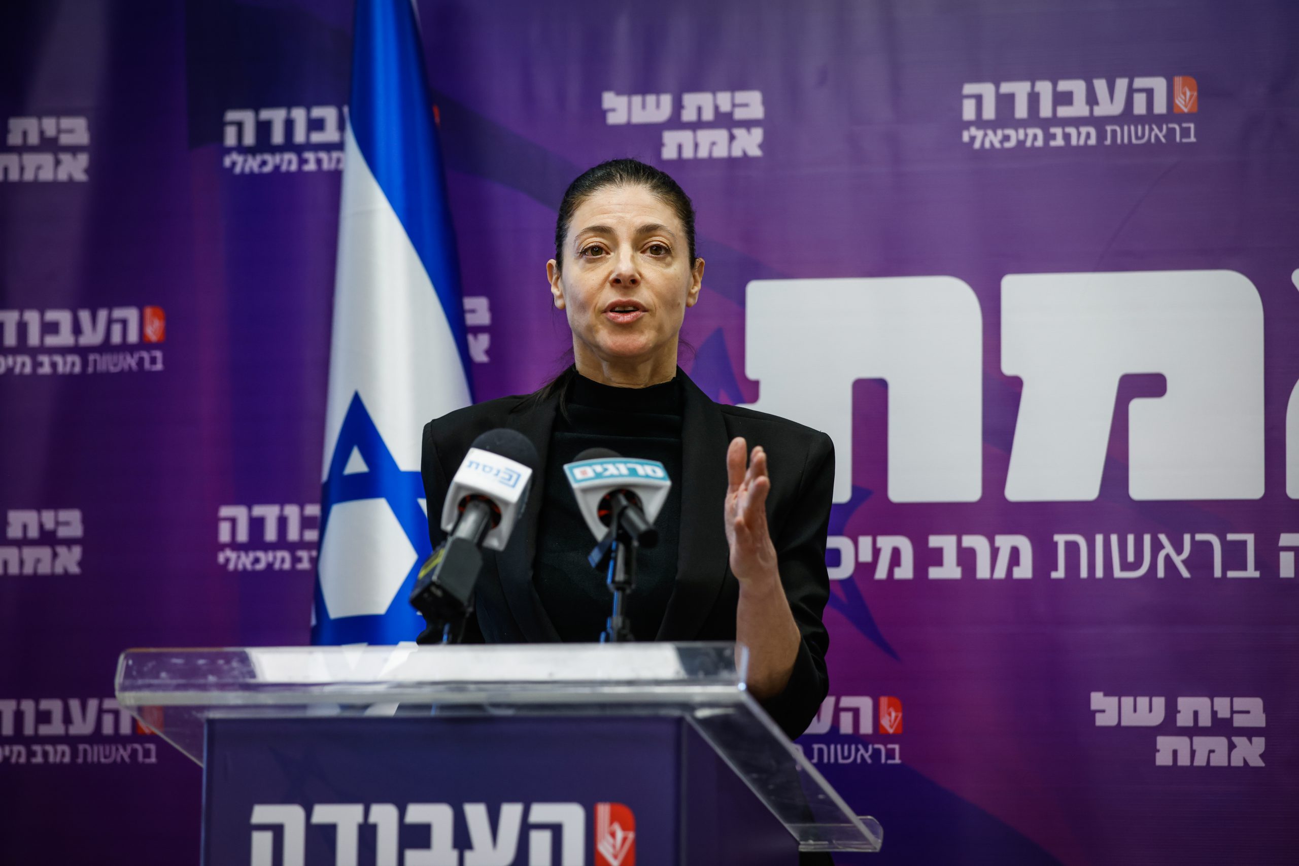 מיכאלי עם שלט סגול של המפלגה