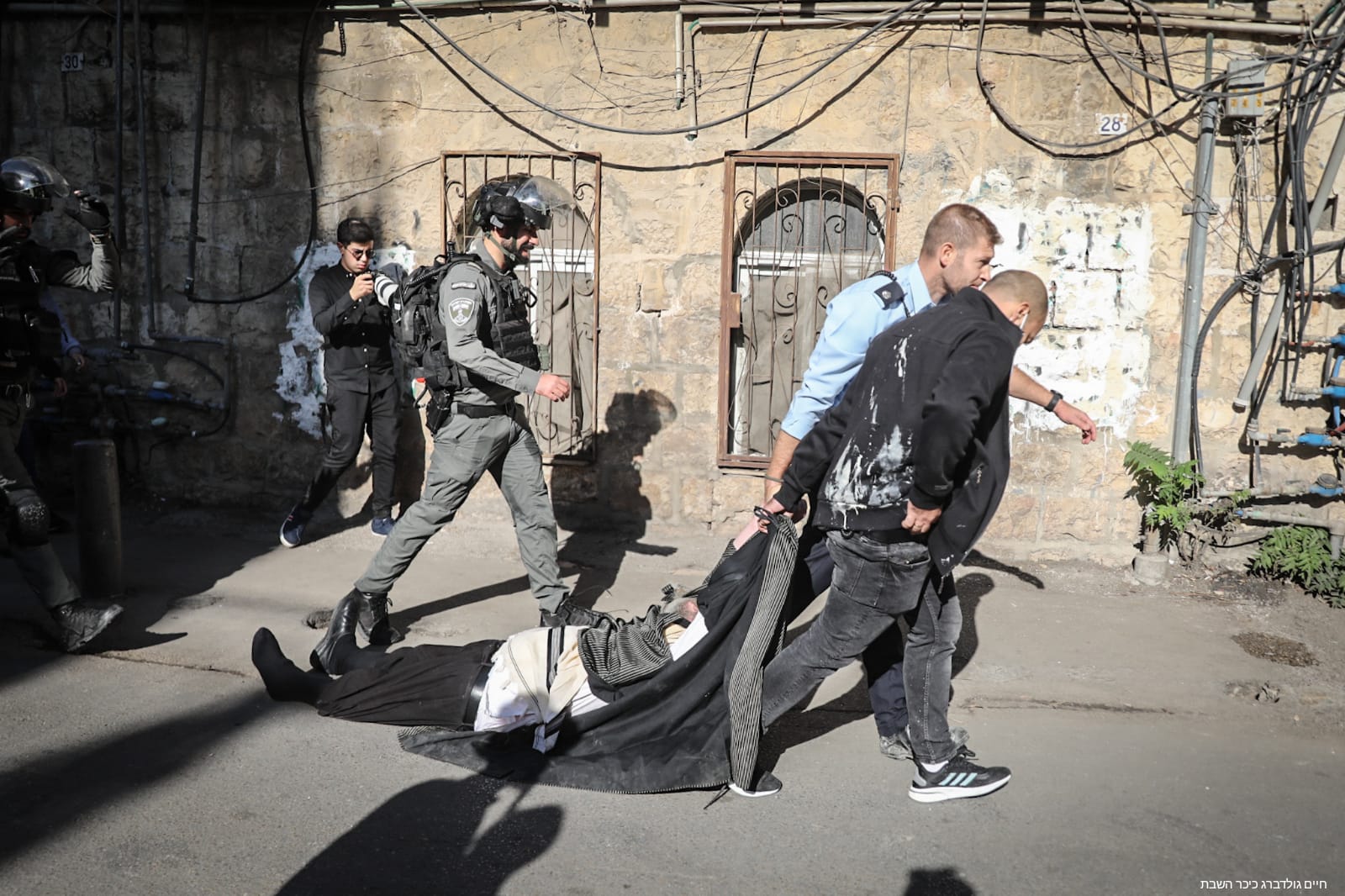 מהומות במאה שערים: צפו בשוטרים גוררים מפגין חרדי