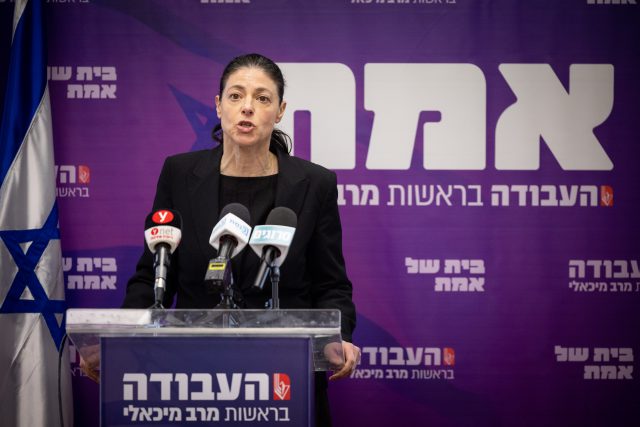 מיכאלי עם השלט הסגול של המפלגה (צילום" יונתן זינדל/פלאש 90)