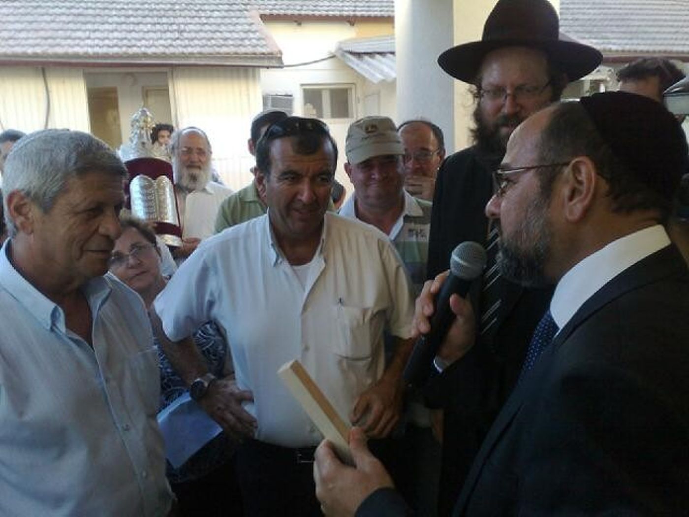 השר מרגי רוקד עם ספרי תורה בכניסה לבית הכנסת