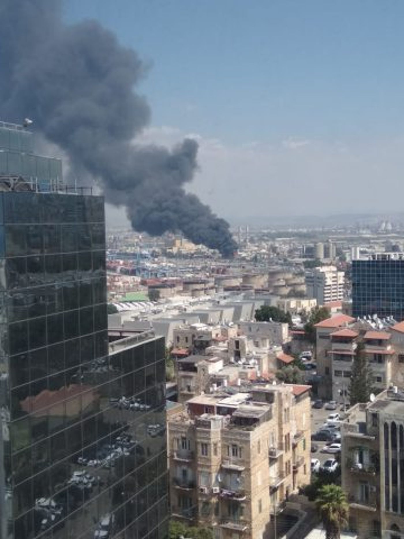 עמוד עשן שחור: שריפת ענק במיכל במפעל שמן בחיפה