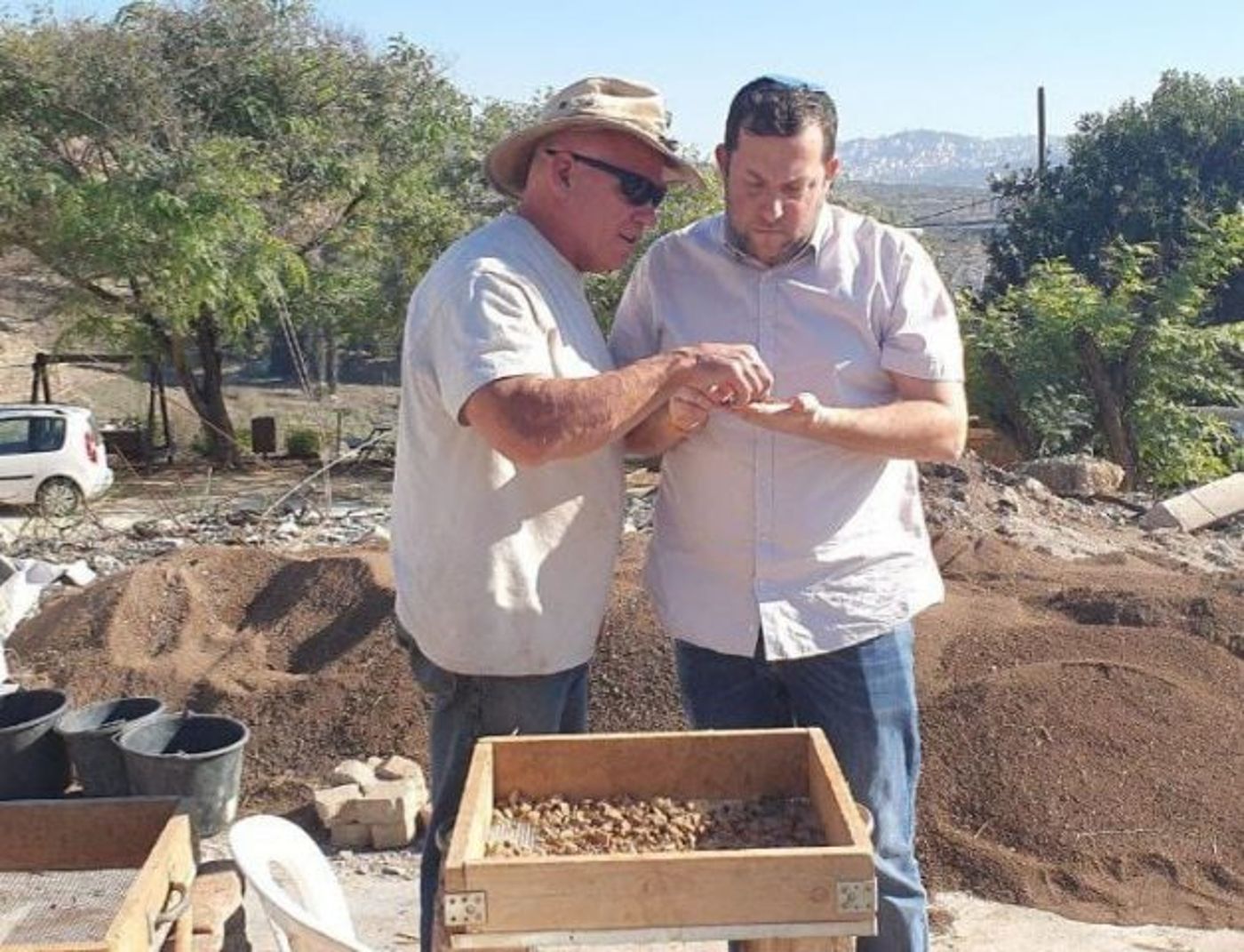צבי קניגסברג מראה לראש מועצת שומרון את הקמע לאחר הסינון. (קרדיט: רועי חדי – דוברות שומרון)