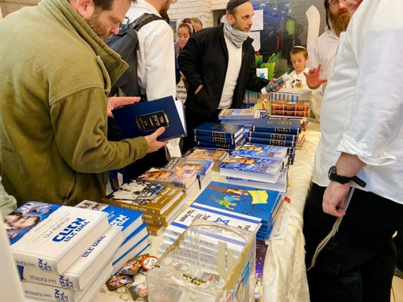בכניסה לאולם השתרך תור ארוך לקניית מרצ'נדייז וספרים