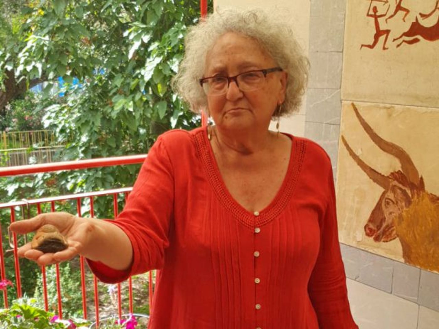 לידיה מרנר מחזיקה את הפסלון שמצאה בגן לאומי חוף פלמחים. (עידן הורן רשות העתיקות)