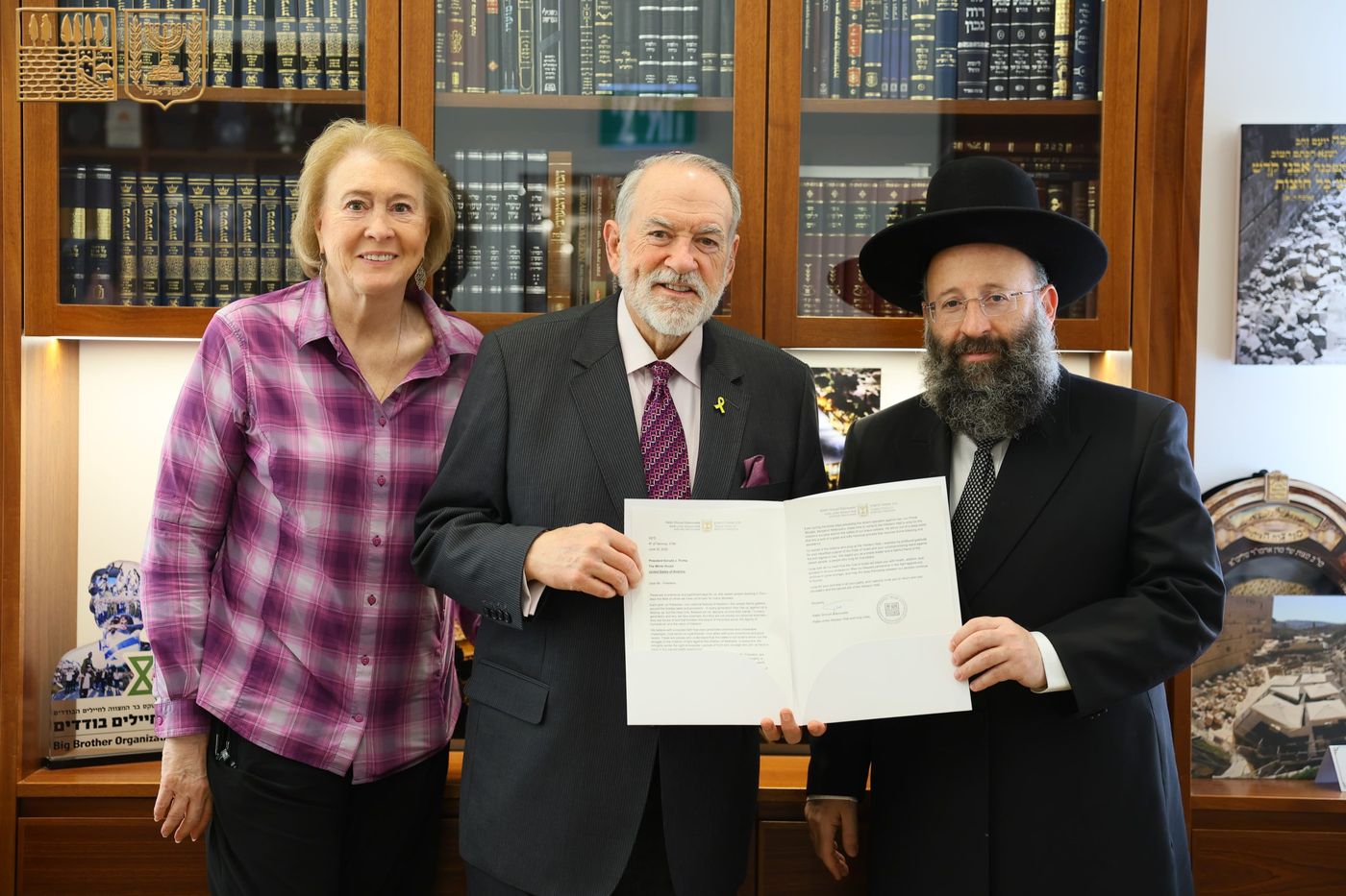 מייק האקבי ורעייתו עם הרב שמואל רבינוביץ'.