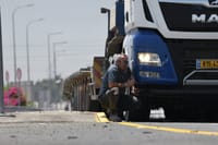 נהג מסתתר מאחורי משאית במהלך אזעקה בעקבות שיגור רקטות מעזה