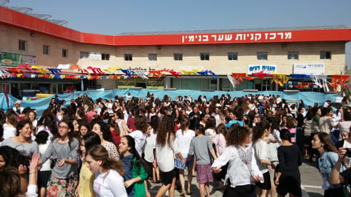 נוער בנימין רוקדים ומחזקים במקום הפיגוע