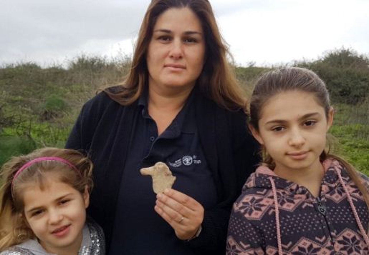 מאיה, איילת והדס גולדברג עם צלמית הסוס מתק' ממלכת ישראל שמצאו בעמק בית שאן. צילום: (ניר דיסטלפלד, רשות העתיקות)