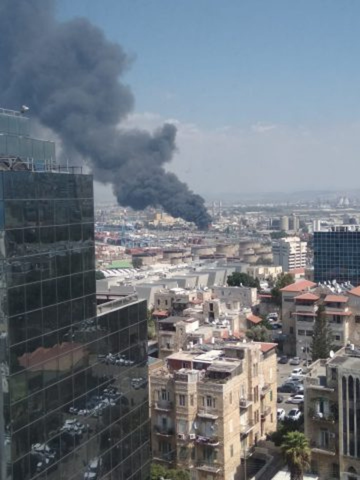 עמוד עשן שחור: שריפת ענק במיכל במפעל שמן בחיפה