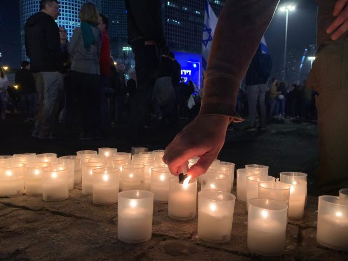 מפגינים מדליקים נרות לזכר קורבנות הפיגוע בירושלים, אמש