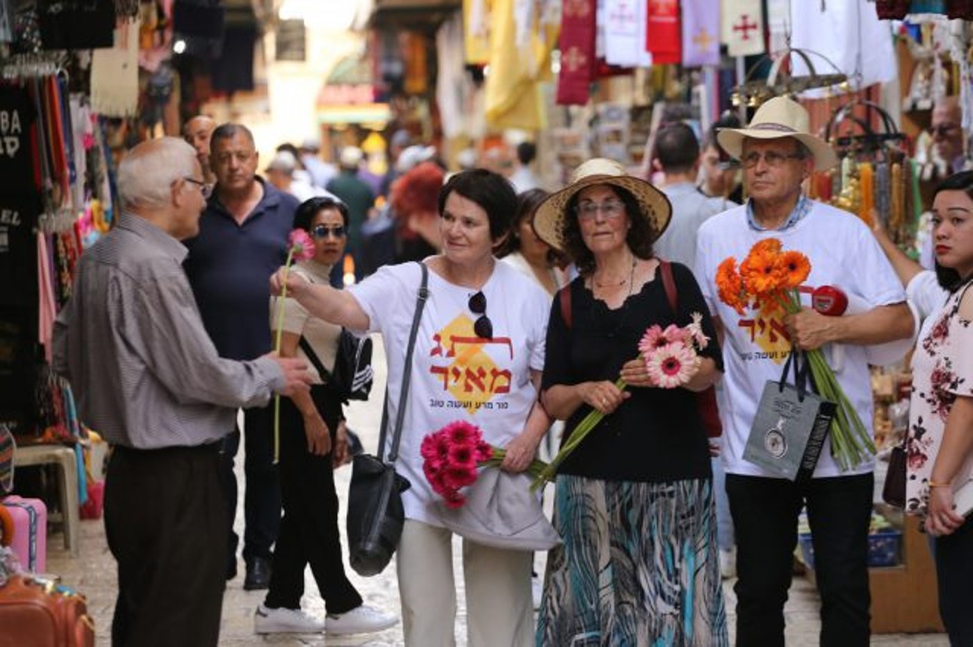 ארגון 'תג מאיר' מחלק פרחים לסוחרים ברובע המוסלמי ביום ירושלים