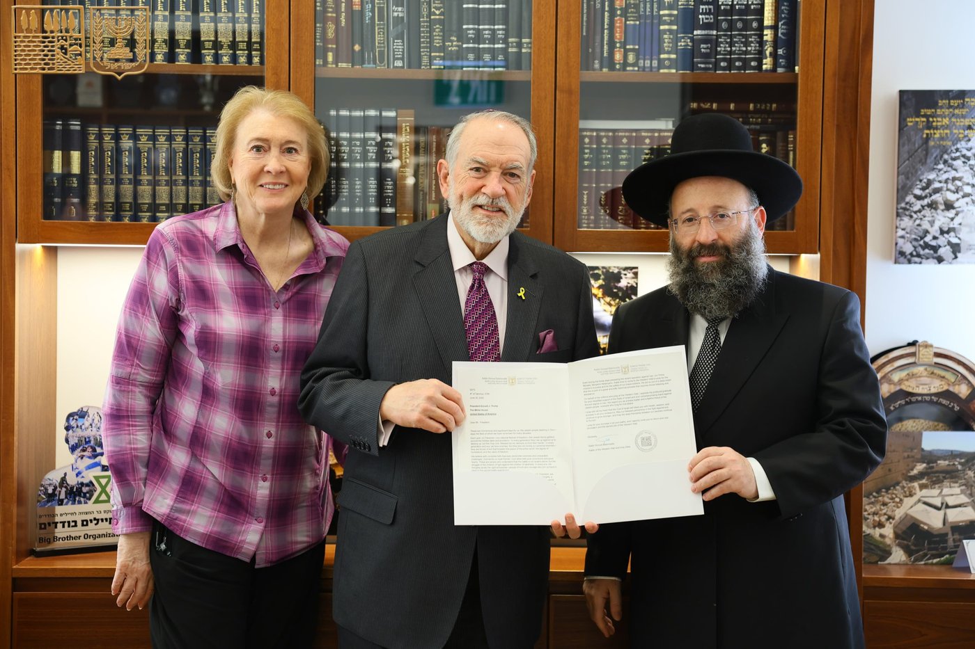 מייק האקבי ורעייתו עם הרב שמואל רבינוביץ'.