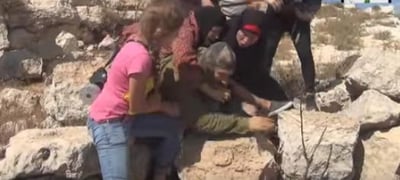 ביזיון: פלסטיניות מכות חייל שאינו יכול להגיב